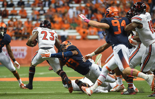 Orange middle linebacker Marqez Hodge attempts to stop Cardinals running back Brandon Radcliff.