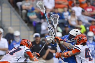 Jones fires a shot toward the net as SU's Joe Gillis and Sean Young contest.