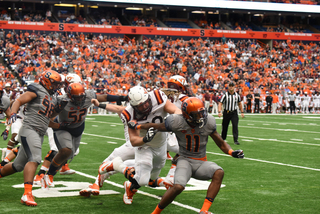 Corey Winfield tries to shed a Hokie blocker as defensive linemen McKinley Williams and Kayton Samuels chase down VT players. 