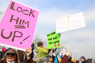 A Syracuse resident holds up a sign that says 