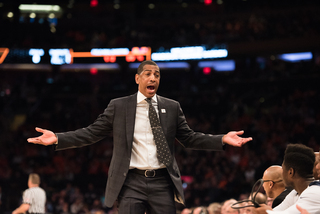 UConn head coach Kevin Ollie gestures toward his bench. 